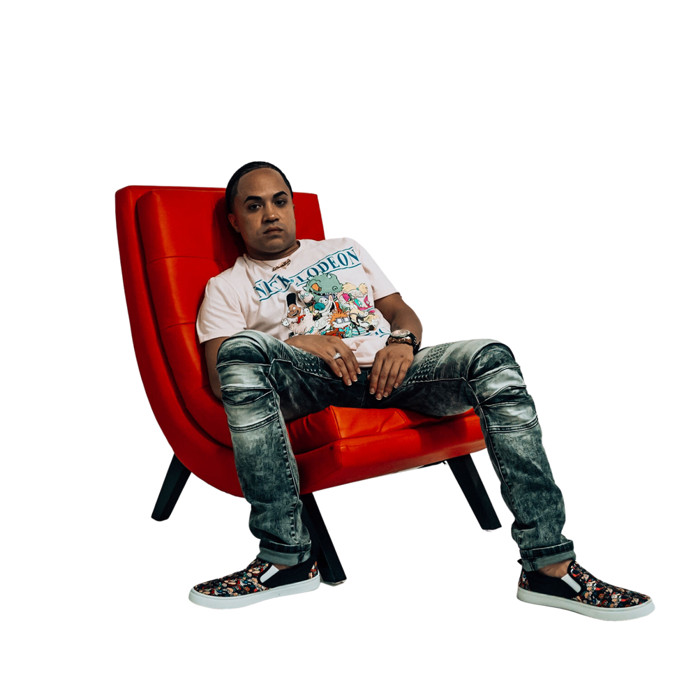 SV EL PADRINO sitting on a red chair in front of a black background